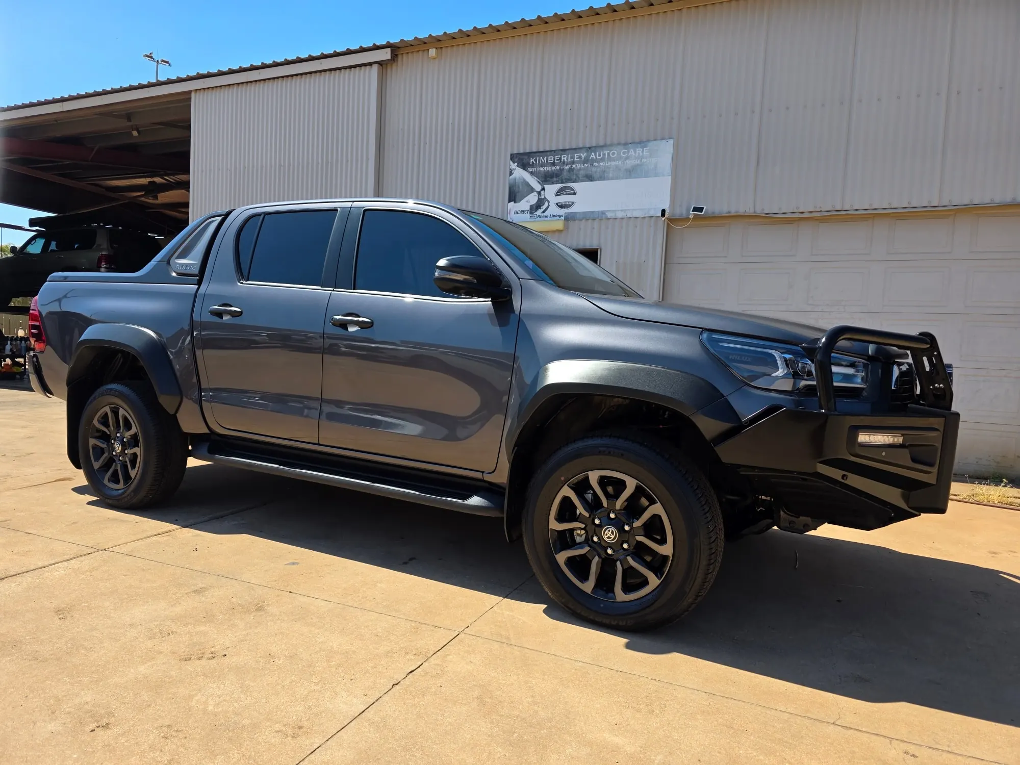 Dark grey Toyota HiLux with bull bar outside Kimberley Auto Care workshop in Broome after professional window Tinting and Detailing